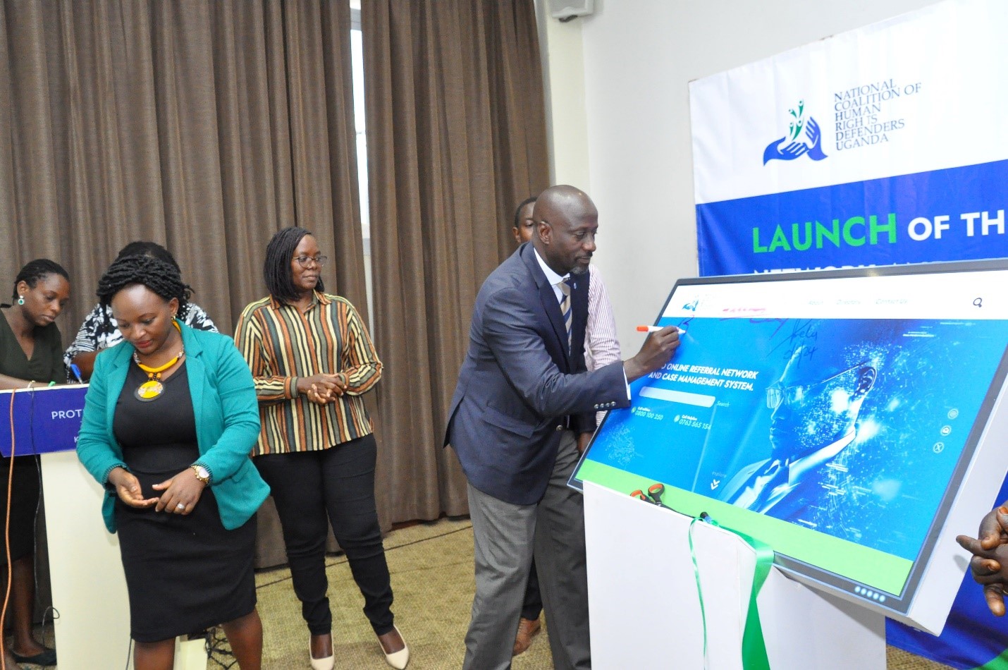 NCHRD-U Executive Director Mr. Robert Kirenga signing on the dummy screen during the launch